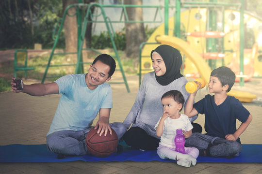 Happy family taking selfie photo at playground