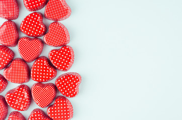 Bright red hearts on mint pastel paper background as decorative border with copy space. Valentine's day youth design concept art.