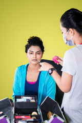 Makeup artist using a sponge to doing makeup