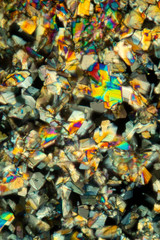 Abstract micrograph of colorful crystals of the amino acid phenylalanine.