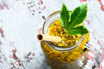 Passion fruit in a glass jar on grey wooden table close-up