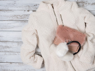 Womens fashion clothes, accessories (plush jacket, crossbody bag, white fur earmuffs). Shopping concept. Flat lay. Winter collection