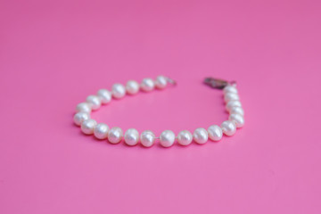 Obraz premium white pearl bracelet on pink background