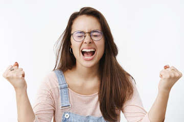Fed up pressured young female coworker in glasses letting out rage and anger yelling out loud with...