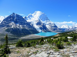 Fototapeta na wymiar An incredible view of a beautiful turquoise lake at the base of two huge mountains and a glacier in Mount Robson Provincial Park, British Columbia, Canada. An epic look at mount robson glacier.