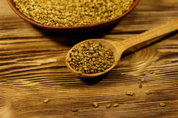 Fenugreek seeds in ceramic plate on wooden table