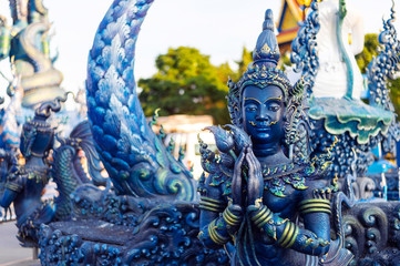 closeup buddha statue in rong sua ten temple (blue temple) with soft-focus and over light in the background, Chiang Rai Province, Thailand