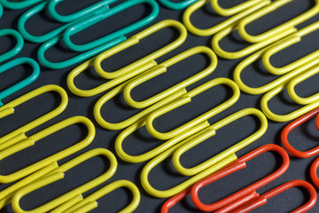 Colorful multicolored paper clips on a black background.