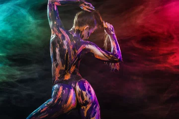 Young woman painted different colors. Inspired dance to music. Body art colorful. An amazing woman with art fashion makeup. © Mike Orlov
