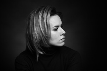 Dramatic black and white portrait of a beautiful woman on a dark background