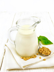 Milk soy in jug with leaf on board