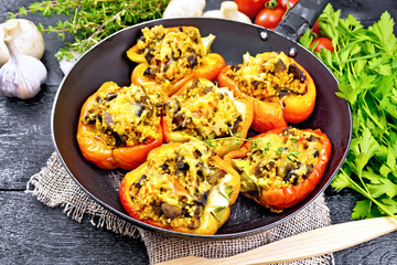 Pepper stuffed with mushrooms and couscous in old pan on burlap