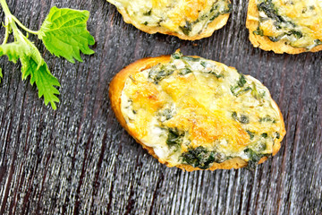 Sandwich of nettle and cheese on dark board top