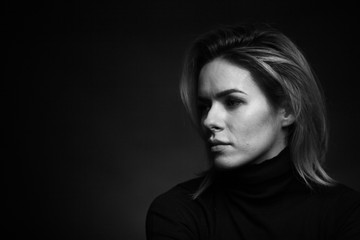Dramatic black and white portrait of a beautiful woman on a dark background