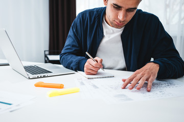 Architect disign concept blueprint. Young man designer sketching a construction project at notebook and drawing plan while working at office