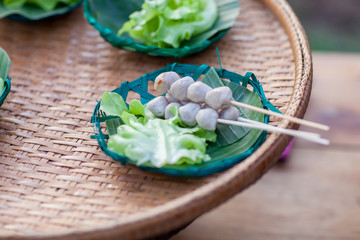Grilled meat ball with sweet spicy sauce on wood dish. Selective focus. grilled pork meatballs with sweet chili sauce on plate. Meat ball on grill / meat ball and pork ball skewer roast on the stove