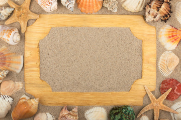 Beautiful wooden frame, stars and seashells on the sand background, with place for your image, text.