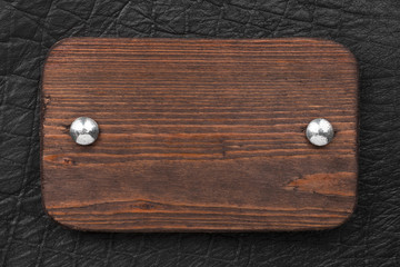 Frame made of wood board, fastened with iron rivets to black leather.