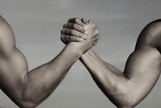 Rivalry, vs, challenge, strength comparison. Two men arm wrestling. Arms wrestling, competition. Rivalry concept - close up of male arm wrestling. Leadership concept. Black and white.