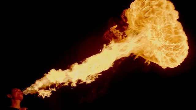 Cool fire show artist breathes fire in dark air, performing amazing stunts - extreme slow motion