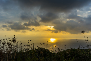 Greece, Zakynthos, Dramatic dark cloudy sky breakthrough of sunrays reflecting on ocean water