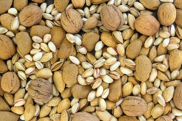 Different types of nuts- assorted walnuts, almonds and pistachios. Concept- healthy diet,  full source of vegetable protein in vegetarianism and raw food. Background.
