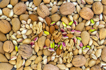 Different types of nuts- assorted walnuts, almonds and pistachios. Concept- healthy diet,  full source of vegetable protein in vegetarianism and raw food. Background.