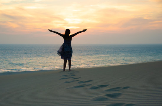 silhouette of Freedom and happy girl on beach. Enjoying serene ocean nature during travel holidays vacation outdoors