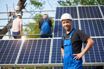 Portrait of smiling successful engineer technician standing in front of unfinished high exterior...