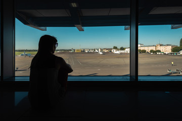 Back view silhouette of female tourist waiting for departure in airport