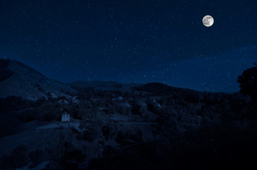 Fototapeta na wymiar Full moon over the ruins of old grunge building at night. Beautiful night landscape with full moon. Azerbaijan