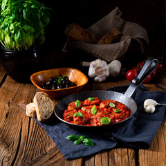 Baked mini meatballs in tomato sauce with basil