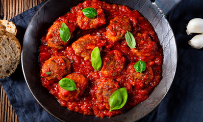 Baked mini meatballs in tomato sauce with basil