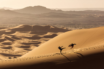 Two people doing karate on dunes in Desert Sahara with beautiful lines and colors at sunrise. Merzouga, Morocco © danmir12