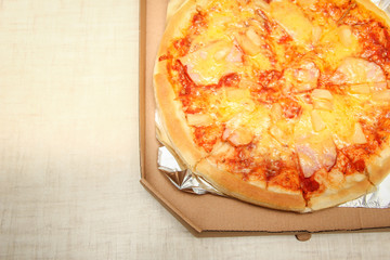 Hot pizza slice with melting cheese on a rustic wooden table