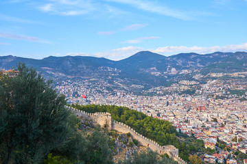 Obraz premium Flag of Turkey over Alanya and medieval wall.