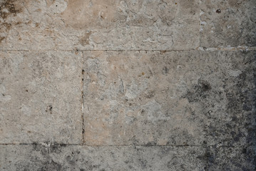 Stone wall texture. Beige concrete wall. Wrinkled rock material. Rough weathered surface for design, covers, textures, pattern. Macro photo.