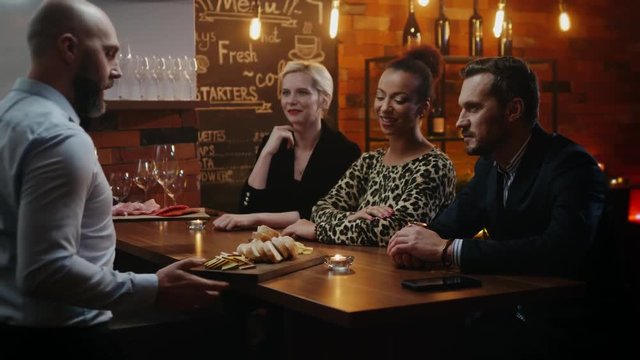 Group of friends having fun talk behind bar counter in a cafe