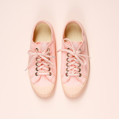 Pink canvas sneakers on pink background, close up