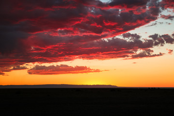 Dramatic sunset / dawn in Gobi Desert with stunning clouds and red sky (Gobi Desert, Mongolia, Asia)