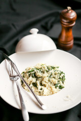 Risotto aux épinards servi sur une assiette cloche