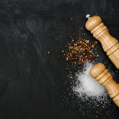 Wooden salt shaker and pepperbox on black chalk board.