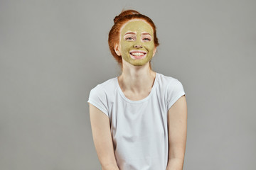 happy girl in white T-shirt with green face looking at the camera. close up photo. happiness, emotion .studio shot