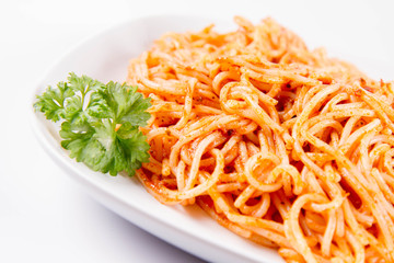 Spaghetti with pesto decorated with parsley on a plate on a white background