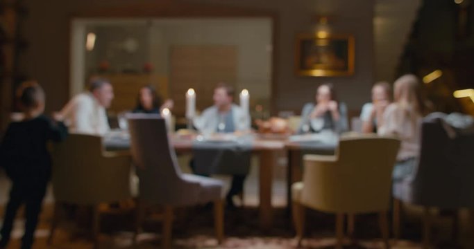 DEFOCUSED BACKGROUND Large multi-generation family having Christmas or Thanksgiving dinner. 4K UHD Blackmagic RAW