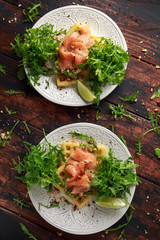 Potato waffles with avocado guacamole and smoked salmon for breakfast