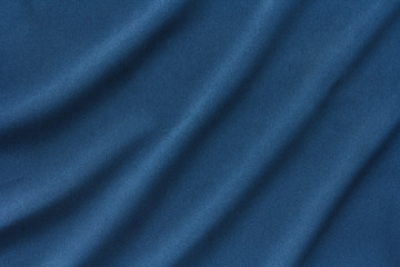 Fototapeta na wymiar dark blue dense fabric with large diagonal folds, abstract background