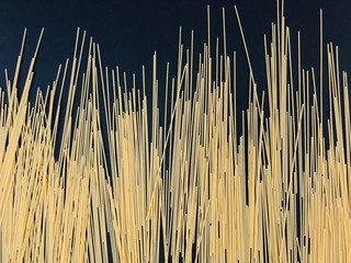 Pasta, ungekochte Spaghetti auf schwarzem Hintergrund
