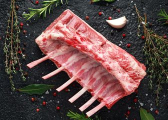raw fresh rack of lamb with green herbs. © grinchh