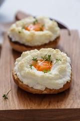 Eggs orsini with greens on wooden background